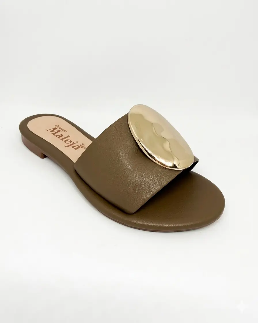 Una sandalia plana café, cálida y combinable, con detalle dorado para looks de oficina o fin de semana.