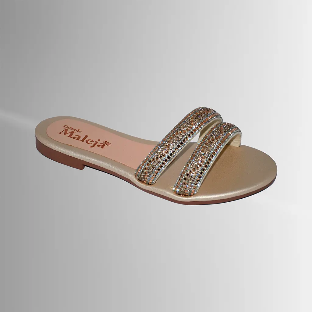 Una sandalia plana dorada, elegante y fácil de combinar para looks casuales o de ocasión.